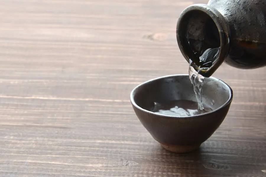 Panduan Minum di Jepang: Cara Menghindari Salah Etiket Kultural 6 Someone Pours a Cup of Sake in Japan